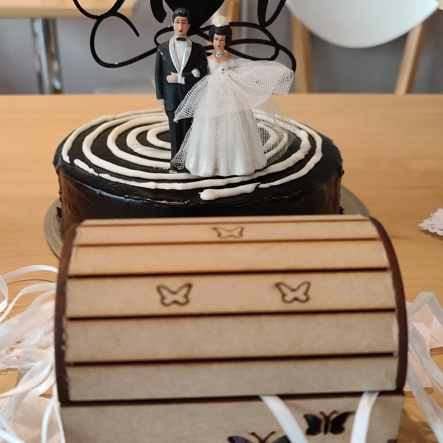 Torta de boda con novios de adorno y una cajita de madera